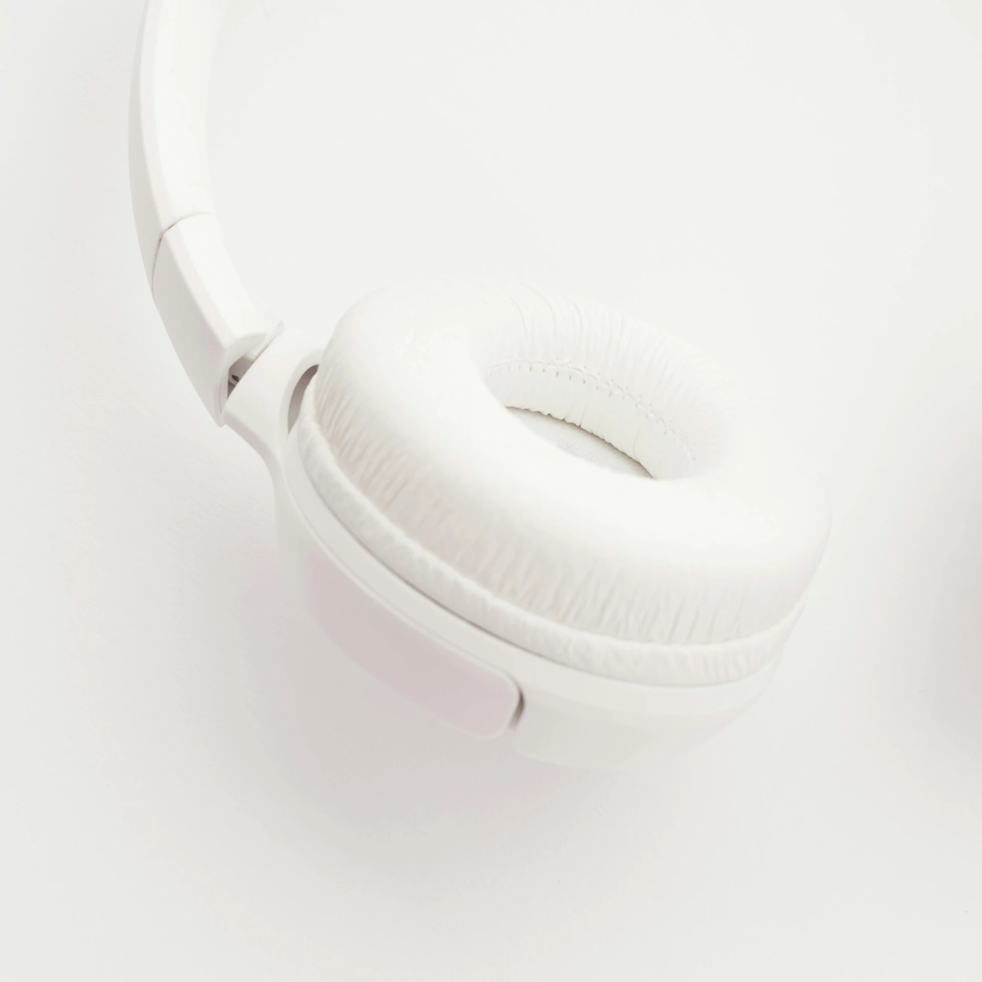 a pair of white headphones on a white surface, by Adam Marczyński, hurufiyya, multiple stories, high quality image, soft white rubber, bubbly
