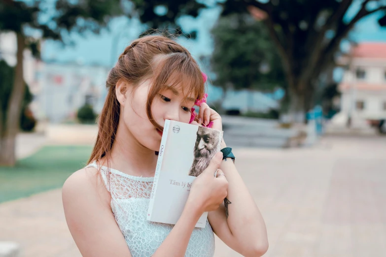 a young girl holding a stuffed animal in her hands, an album cover, by Tan Ting-pho, pexels contest winner, realism, holding a book, skincare, attractive girl, tourist photo