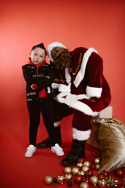 a little boy sitting next to a big man dressed like santa