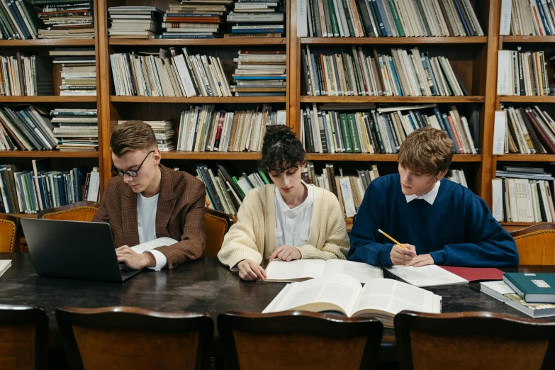 a group of people sitting at a table in front of a laptop, unsplash, academic art, boys, old library, lachlan bailey, ignant
