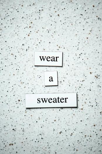 a sign that says wear a sweater on it, concrete poetry, promo image, three, metal garments