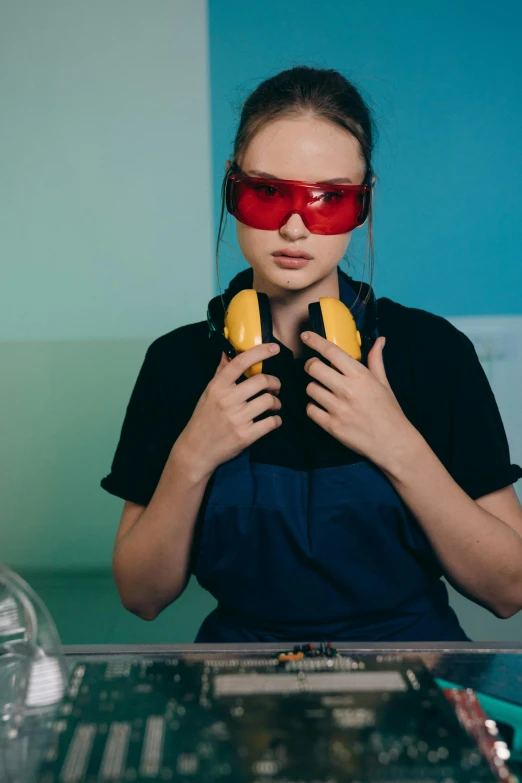 a woman holding a banana in front of her face, a colorized photo, trending on pexels, hypermodernism, wearing plumber uniform, red hot soldering iron, round goggles, carpenter