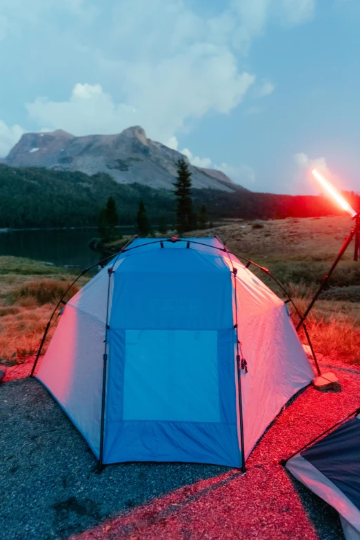 a couple of tents sitting on top of a field, red light saber, lake setting, blue rim lighting, like a catalog photograph