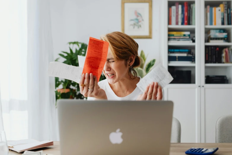 a woman that is sitting in front of a laptop, by Julia Pishtar, pexels contest winner, throwing cards in the air, paper origami, laughing hysterically, wrinkles and muscle tissues