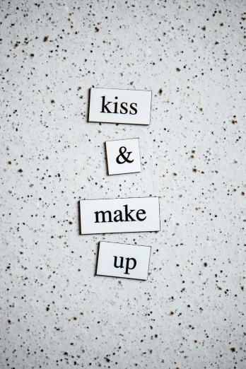 a piece of paper that says kiss and make up, an album cover, by Anita Malfatti, trending on unsplash, concrete poetry, 256435456k film, magnetic, porcelain