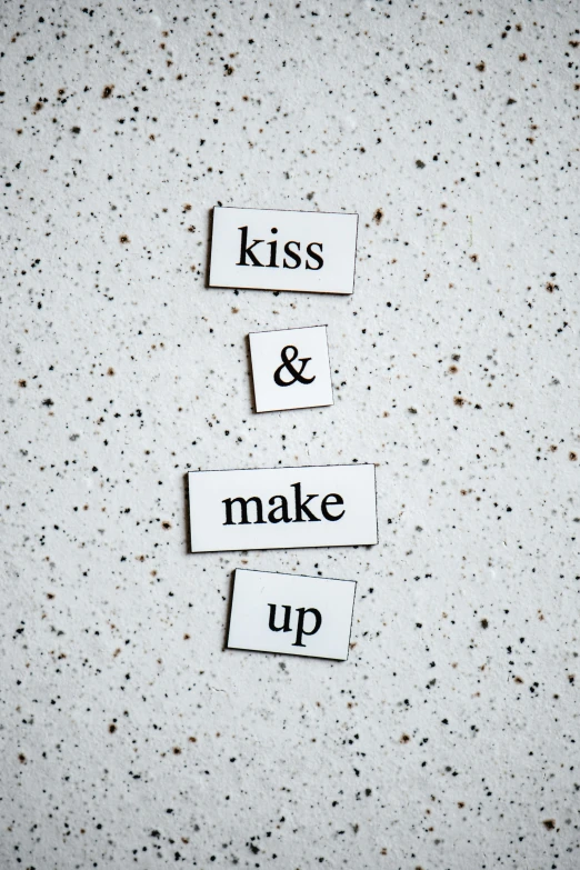 a piece of paper that says kiss and make up, an album cover, by Anita Malfatti, trending on unsplash, concrete poetry, 256435456k film, magnetic, porcelain