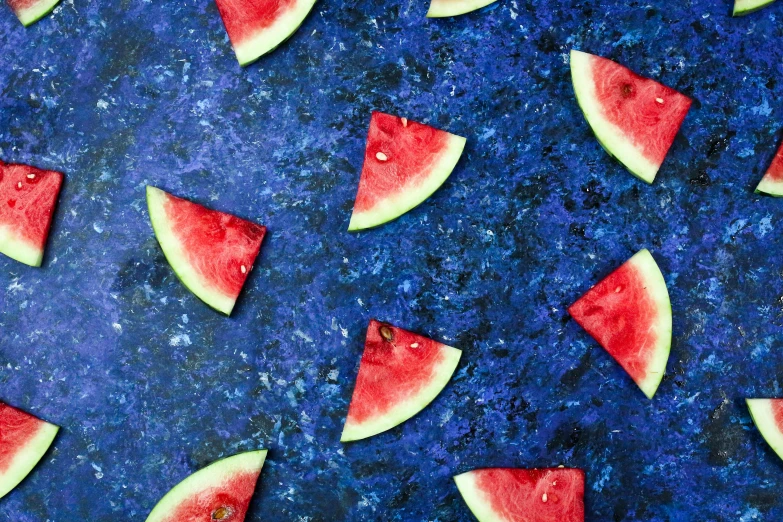 a group of slices of watermelon on a blue surface, by Julia Pishtar, trending on unsplash, abstract expressionism, carved from sapphire stone, indigo and venetian red, 2000s photo, dezeen