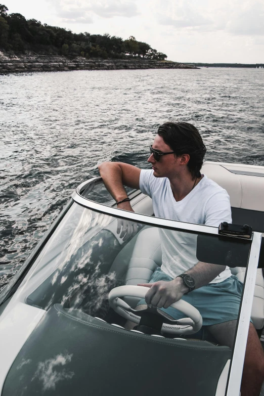 a man driving a boat on a body of water, happening, harry styles, sharp jawline, trending on vsco, sydney hanson