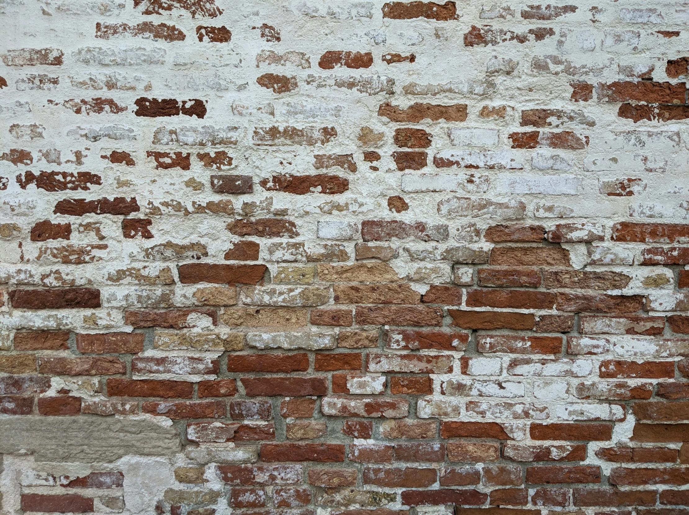 an old red brick wall with a light green fire hydrant next to it