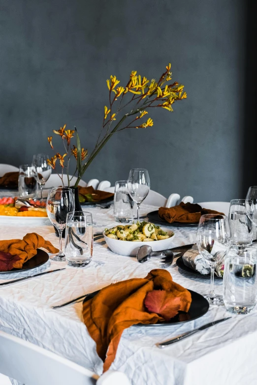 the dinner table is set with flowers and place settings