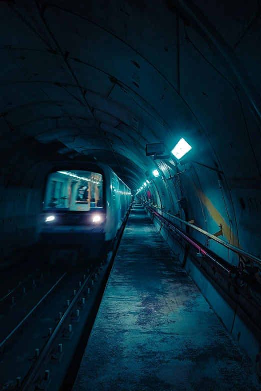 a subway train traveling through a tunnel at night, inspired by Elsa Bleda, unsplash contest winner, inside a futuristic army base, extremely moody blue lighting, 2022 photograph, concrete