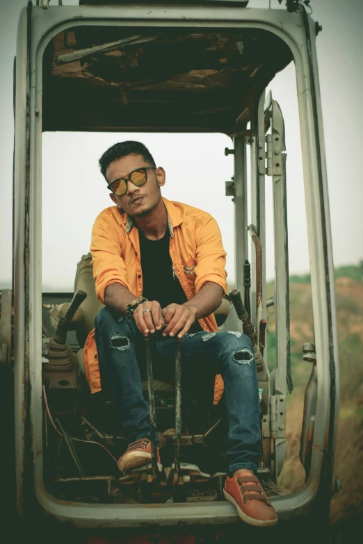 a man sitting in the back of a truck, an album cover, inspired by Rudy Siswanto, pexels contest winner, sumatraism, man with glasses, indian, on a farm, vocalist