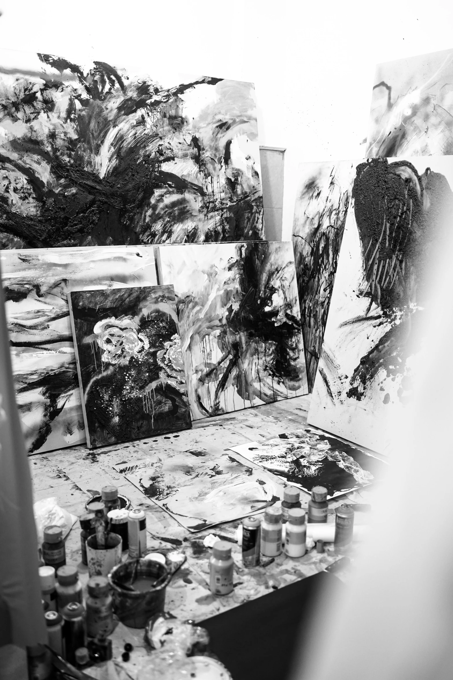 a black and white photo of an artist's studio, inspired by Gabriel Ba, palette knife! and brush strokes, full of paintings of angels, svetlana tigai, ffffound