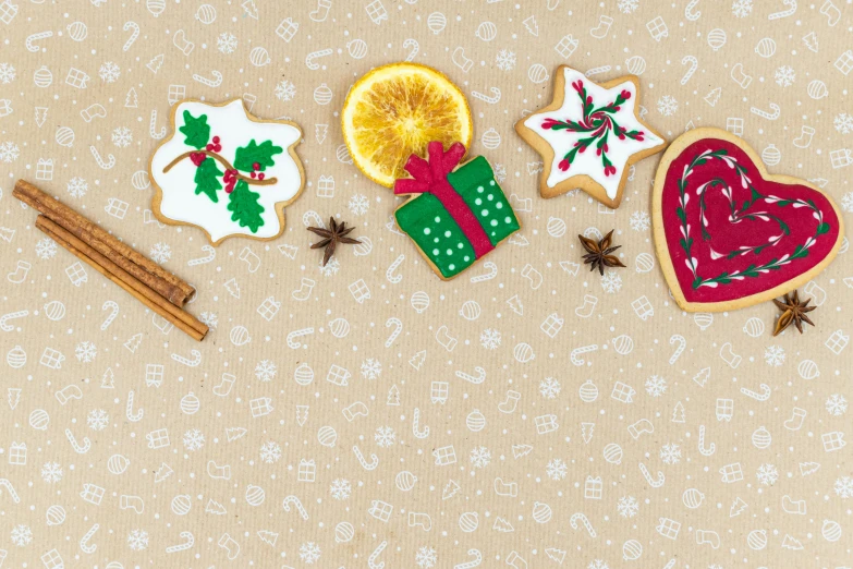 a couple of cookies sitting on top of a table, by Emma Andijewska, pexels, naive art, background image, christmas, textile, ribbon