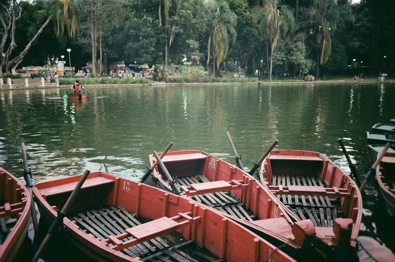 a number of small boats in a body of water, by Elsa Bleda, pexels contest winner, hurufiyya, in a park and next to a lake, coban, agfa film, red water