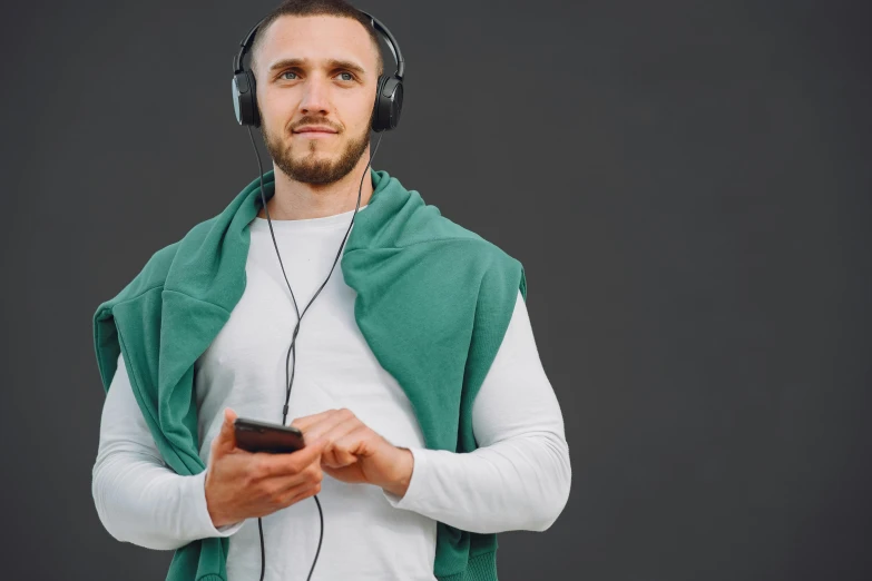 young man wearing headphones and holding phone