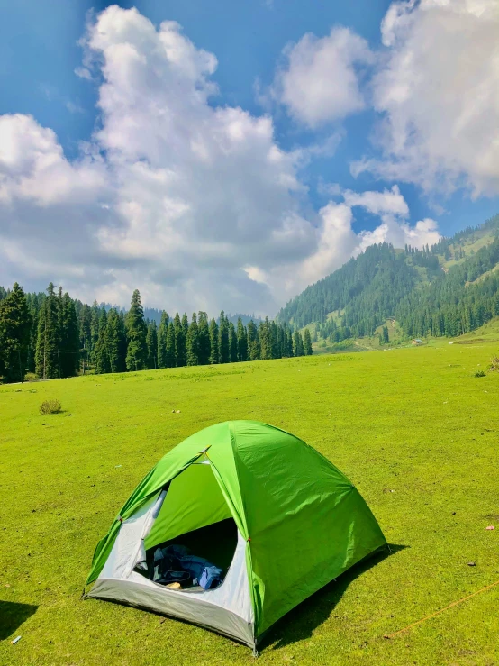 a green tent sitting on top of a lush green field, by Muggur, touring, profile pic