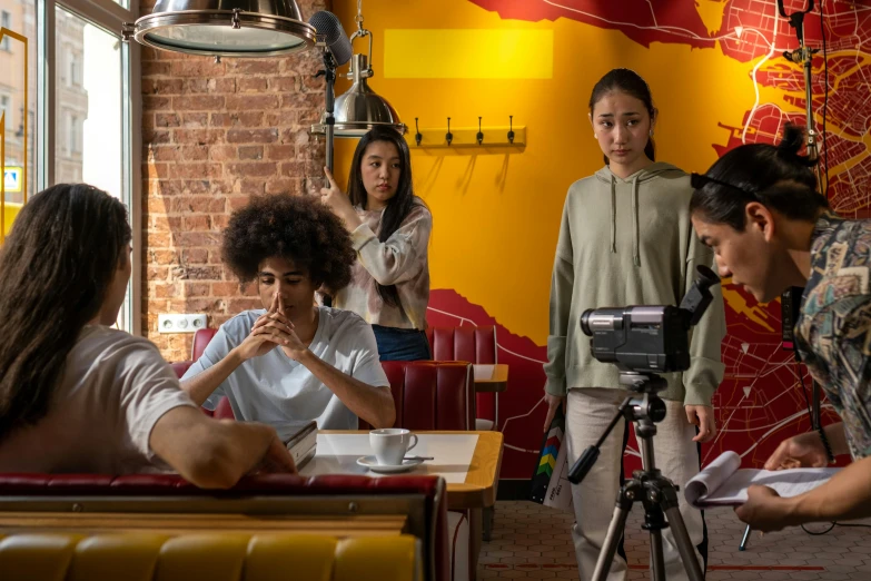 a group of people sitting around a table, ashteroth, film shooting, standing in a restaurant, ( ( theatrical ) )