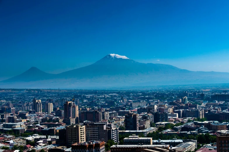 a large city with skyscrs and a tall mountain in the background