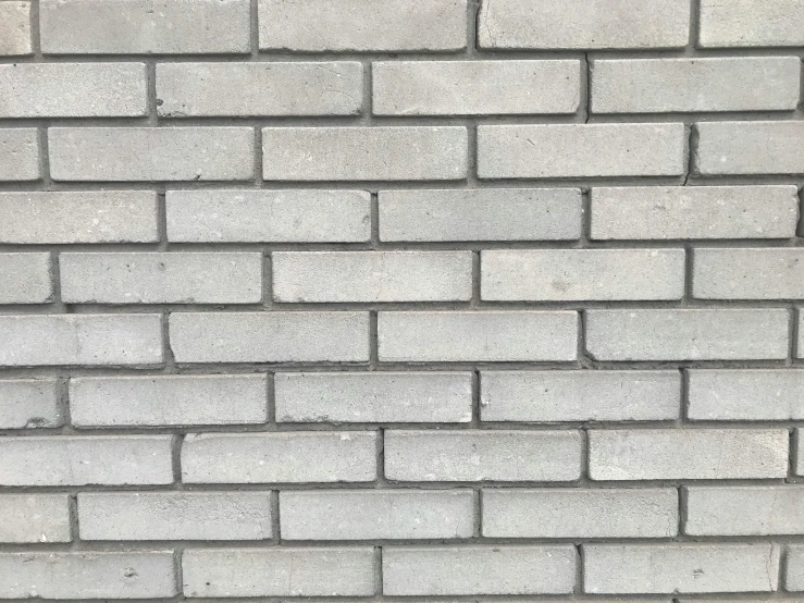 a very big white brick wall next to a parking meter