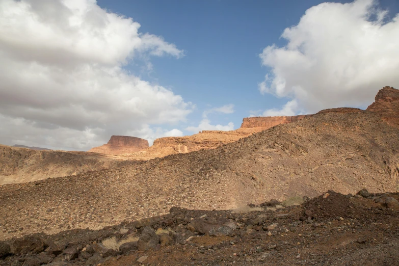 mountains with brown soil against a cloudy sky