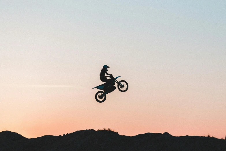 a man flying through the air while riding a dirt bike, pexels contest winner, at twilight, avatar image, petrol aesthetic, profile image