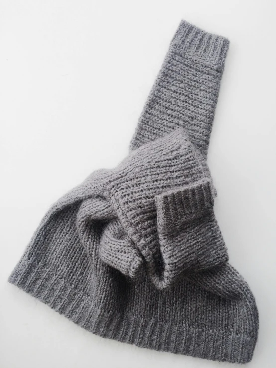 the back of a gray knitted mitten on a white background