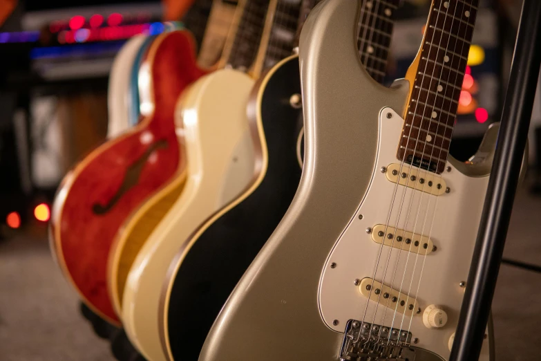 a group of guitars sitting next to each other, private press, fender stratocaster, profile image, retro colour, on display