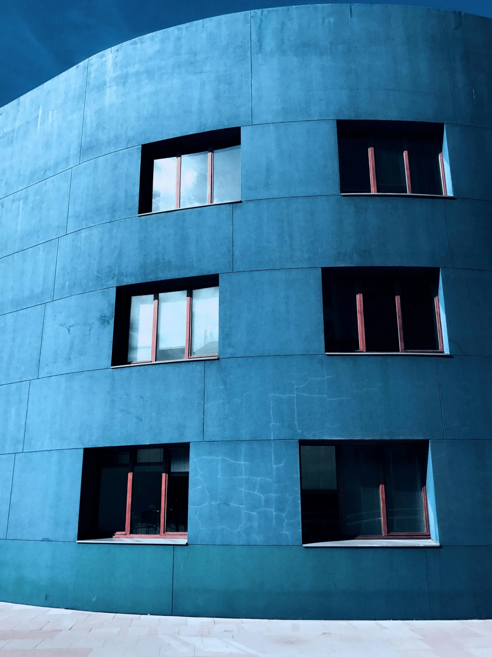 a red fire hydrant sitting in front of a blue building, an album cover, inspired by Tadao Ando, pexels contest winner, modernism, steel window mullions, curvy build, apartment building on the moon, windows and walls :5