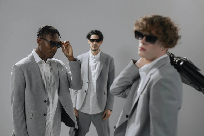 three men in suits and sunglasses standing next to each other, inspired by Michael Ray Charles, pexels contest winner, bauhaus, grey clothes, white trendy clothes, thumbnail, fashion model features