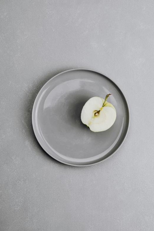 an apple sitting on top of a plate on a table, inspired by Maruyama Ōkyo, instagram, minimalism, in gunmetal grey, made of glazed, round-cropped, celebration