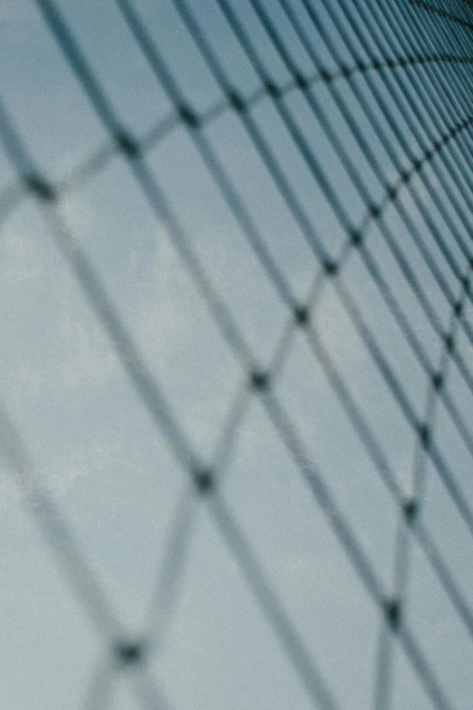 a large jetliner flying through a blue sky, a picture, unsplash, modernism, fence, fishnet, grainy movie still, unfocused