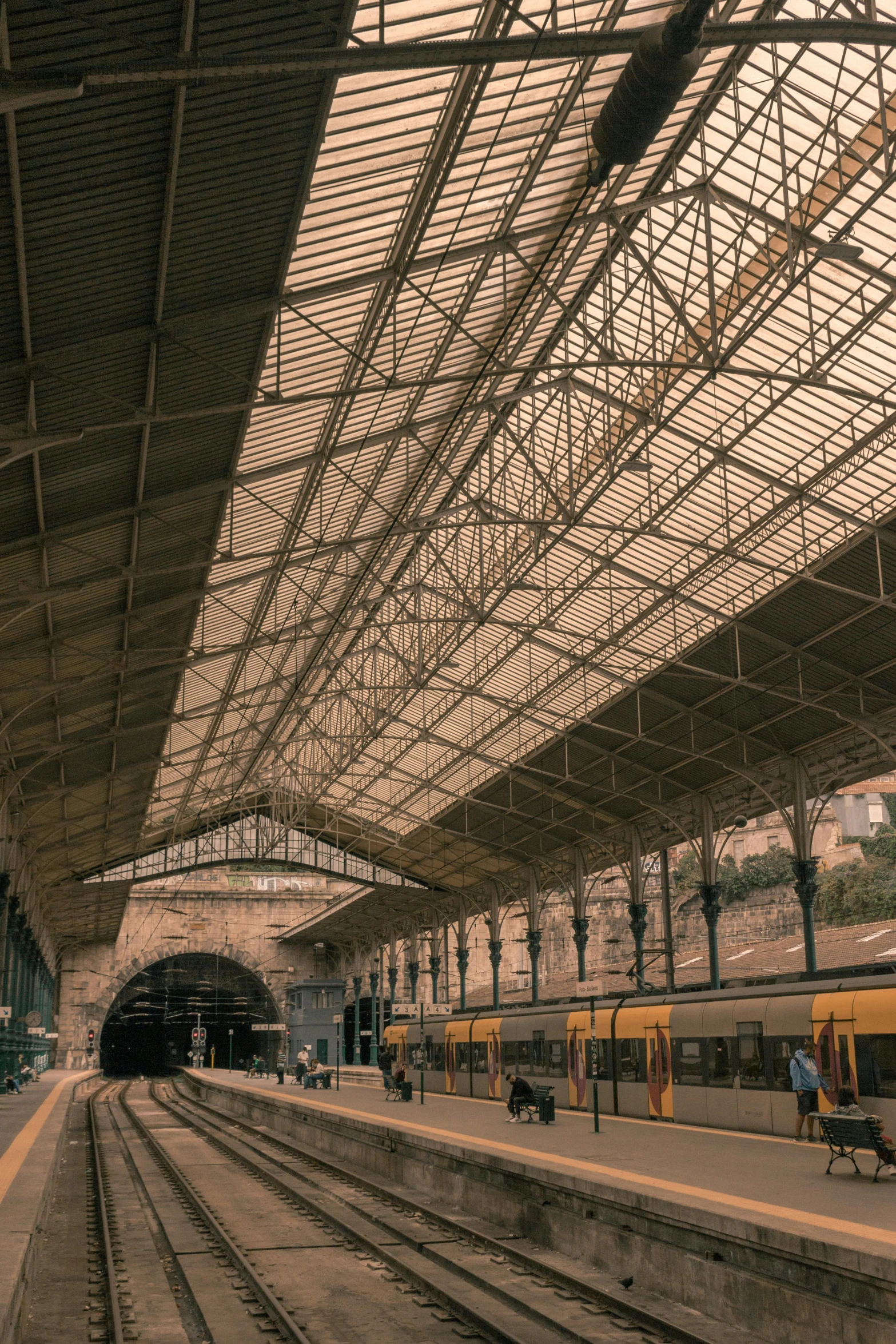 a train station with a train pulling into the station, by Nadir Afonso, pexels contest winner, art nouveau, simple gable roofs, panoramic shot, square, full frame image