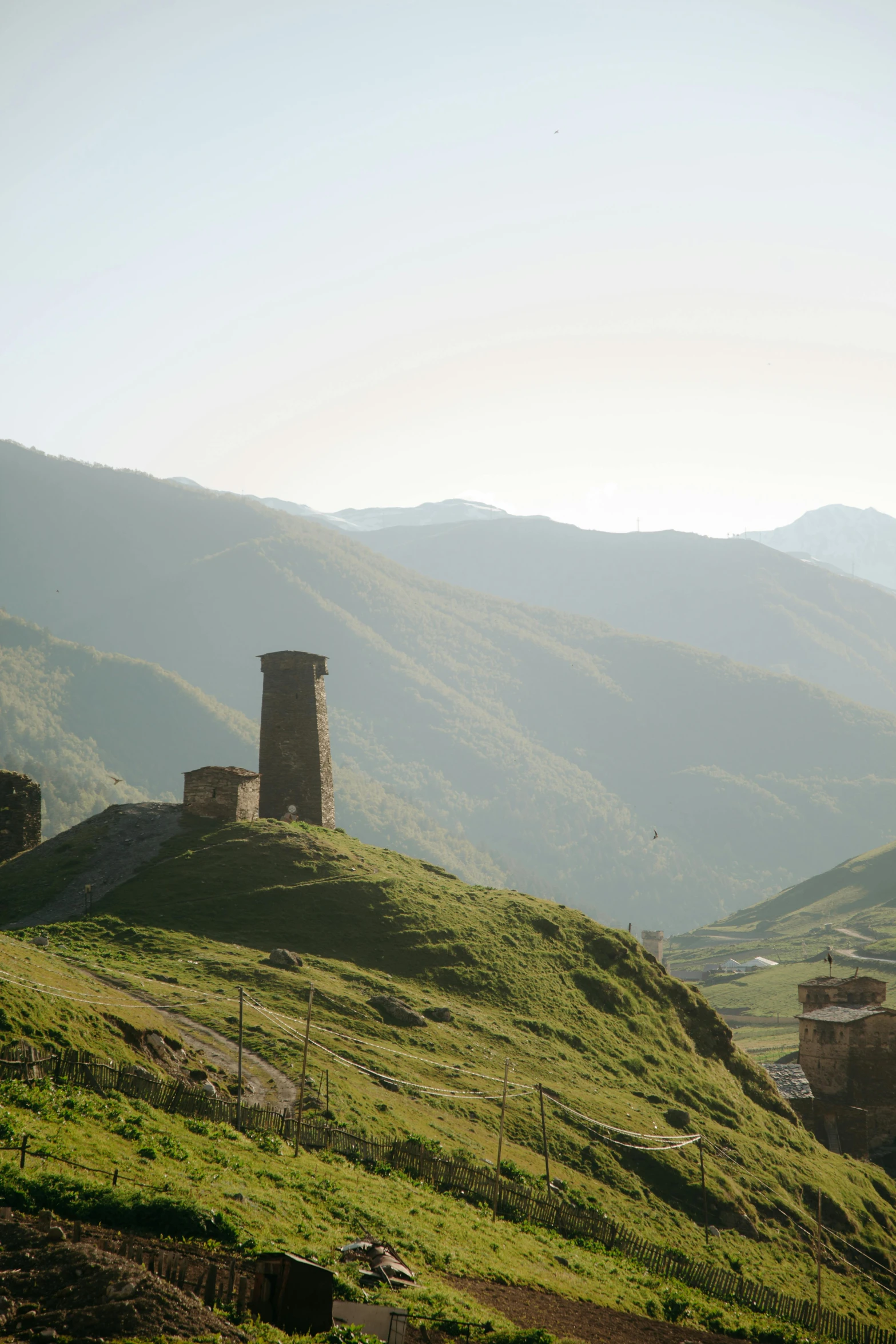 an old tower building is on top of a hill