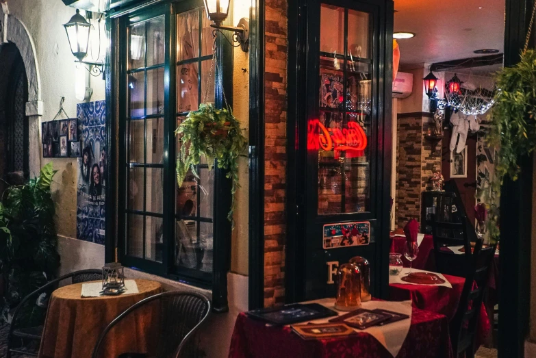 the outside of a restaurant with tables and chairs, by Meredith Dillman, pexels contest winner, art nouveau, dive bar with a karaoke machine, moroccan new york city street, maroon and blue accents, a cozy