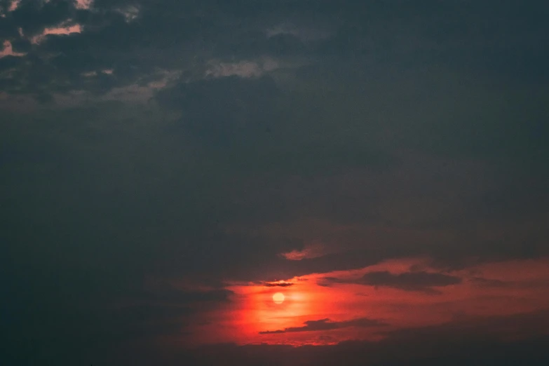 the sun rising behind some clouds over an island