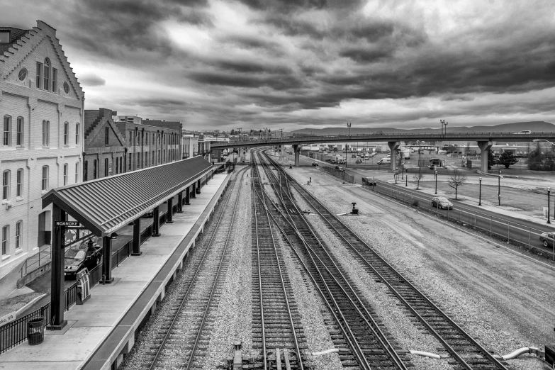 a black and white photo of a train station, a black and white photo, by Dave Melvin, realism, clouds around, rafeal albuquerque, hdr color, high angle view