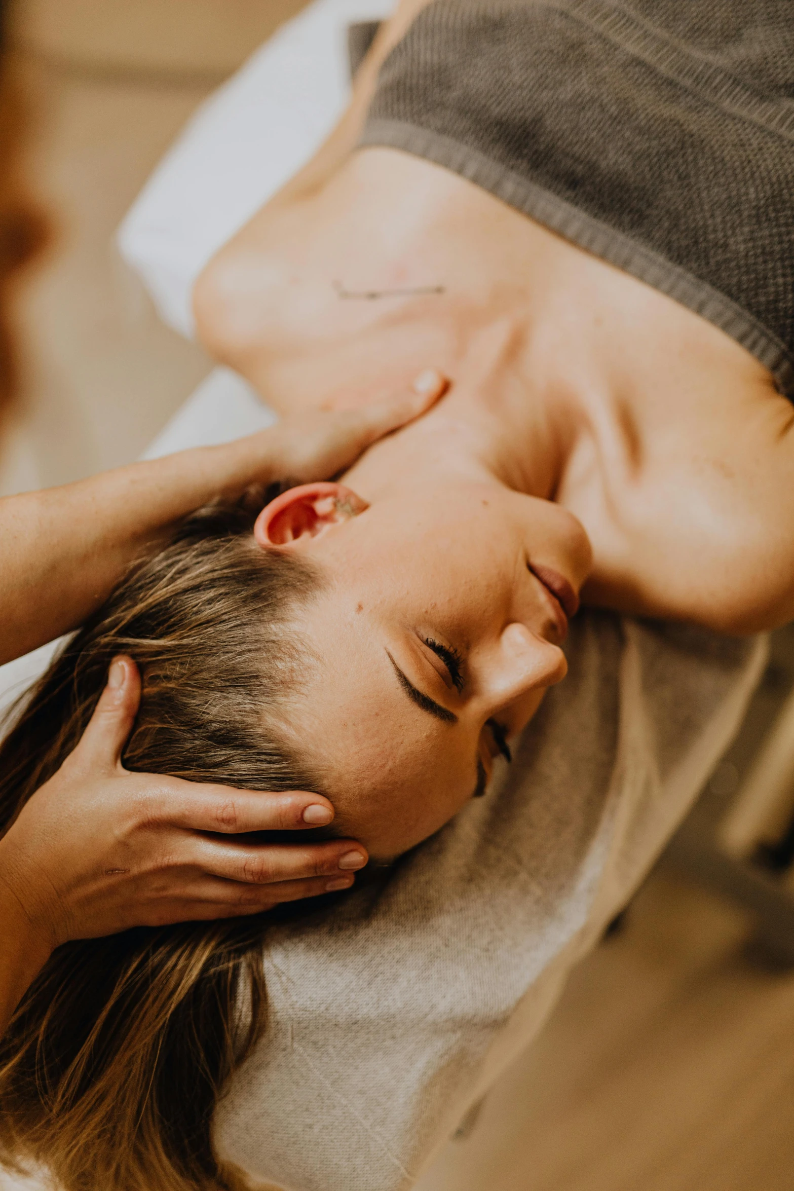 a woman getting a massage at a spa, by Adam Marczyński, pexels contest winner, tight around neck, thumbnail, brown, head tilted downward