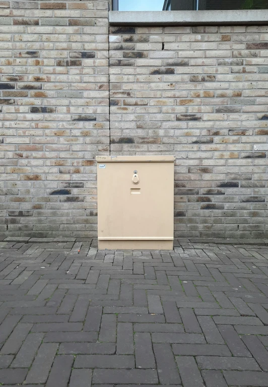 a closed storage cabinet on a sidewalk near a building