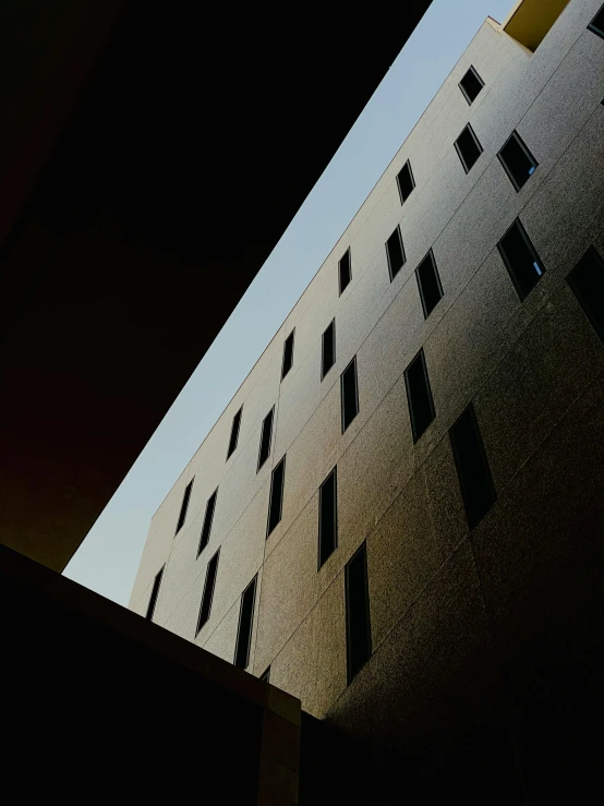 a black and white photo of a tall building, an album cover, inspired by David Chipperfield, unsplash contest winner, beige and dark atmosphere, windows and walls :5, back - lit, blue sky