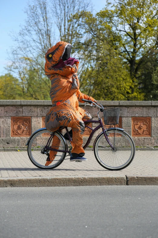 a person in an orange costume riding a bike