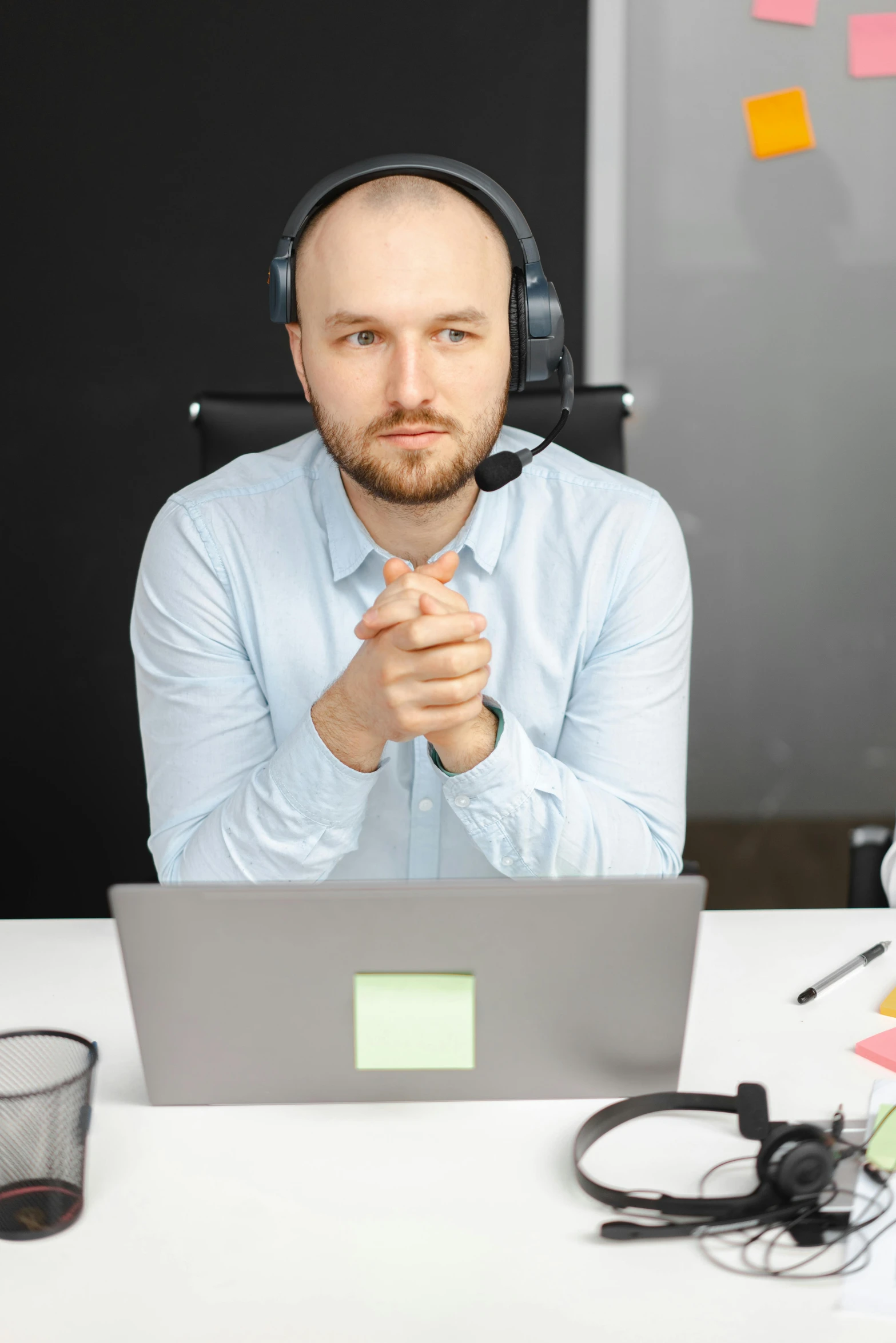 a man sitting at a desk with a laptop and headphones, holding a microphone, it specialist, thumbnail, centered in image
