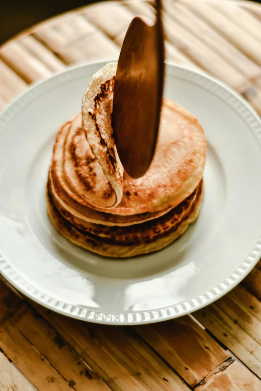 a wooden spatula is sticking out of the top of pancakes