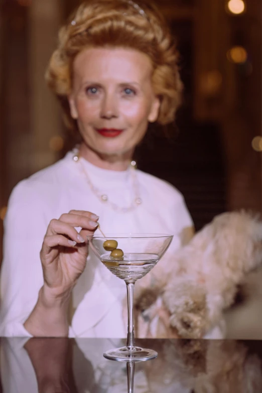 woman in white shirt holding up a martini glass