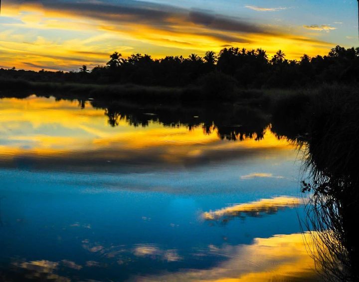 a body of water with a sunset in the background, blue and yellow fauna, thumbnail, reflection echo, jamaica