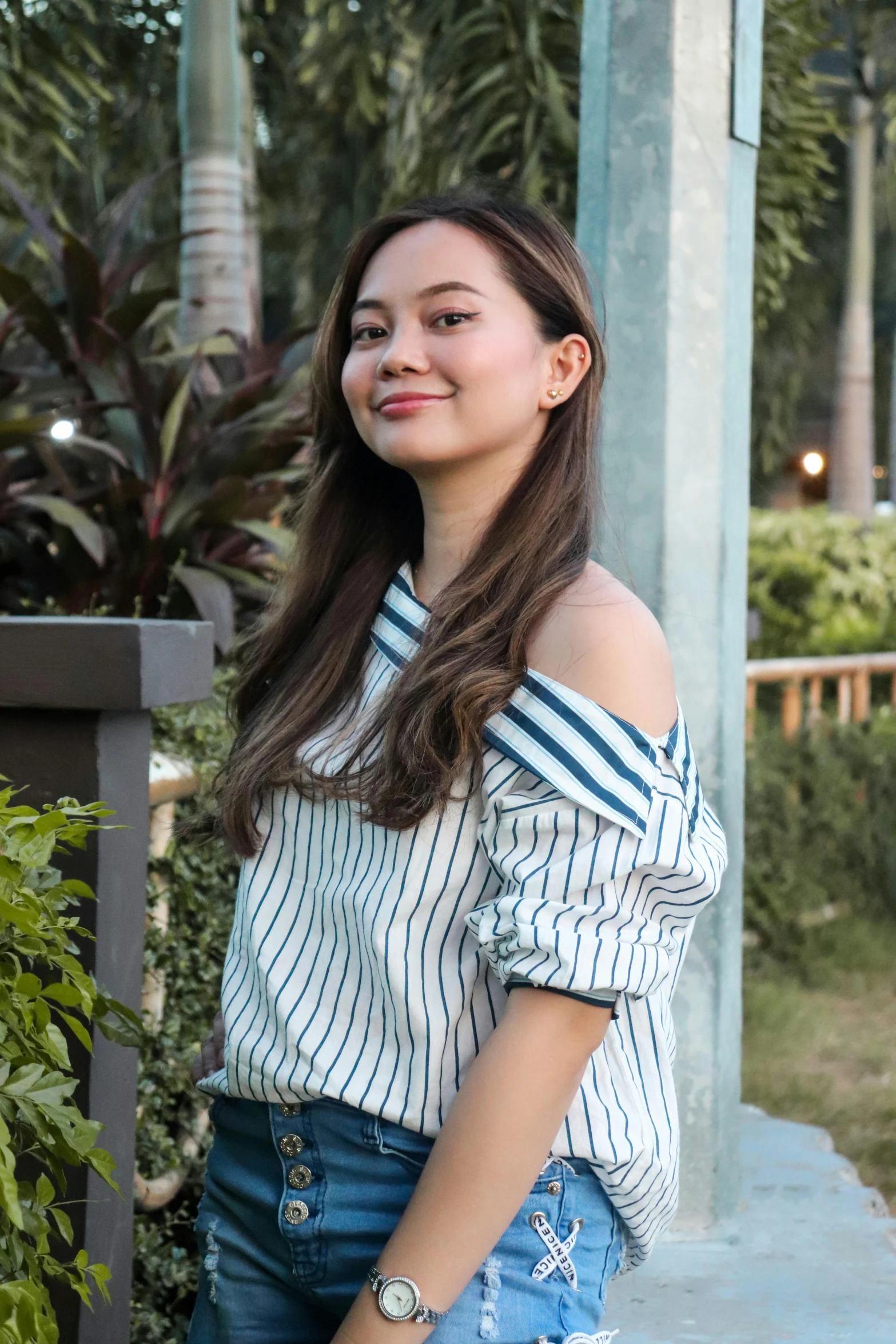 an asian girl in a  shirt and denim shorts smiling