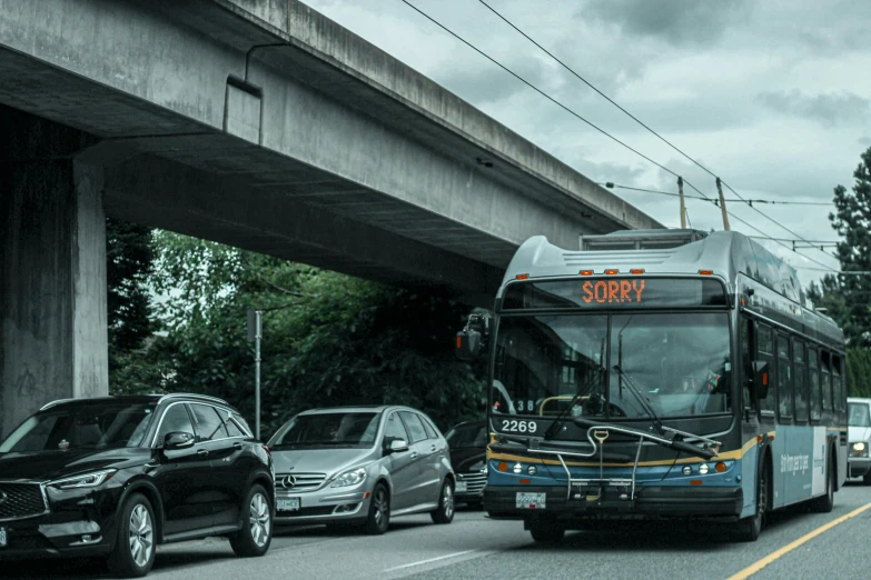 a bus that is sitting on the side of the road, by Carey Morris, unsplash, happening, under bridge, vancouver, looking threatening, 🚿🗝📝