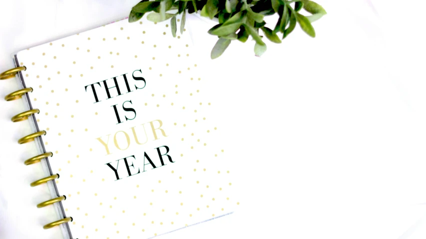 a notebook with the words this is your year written on it, a photo, trending on pexels, minimalism, decorations, white and gold, background image, 🐿🍸🍋