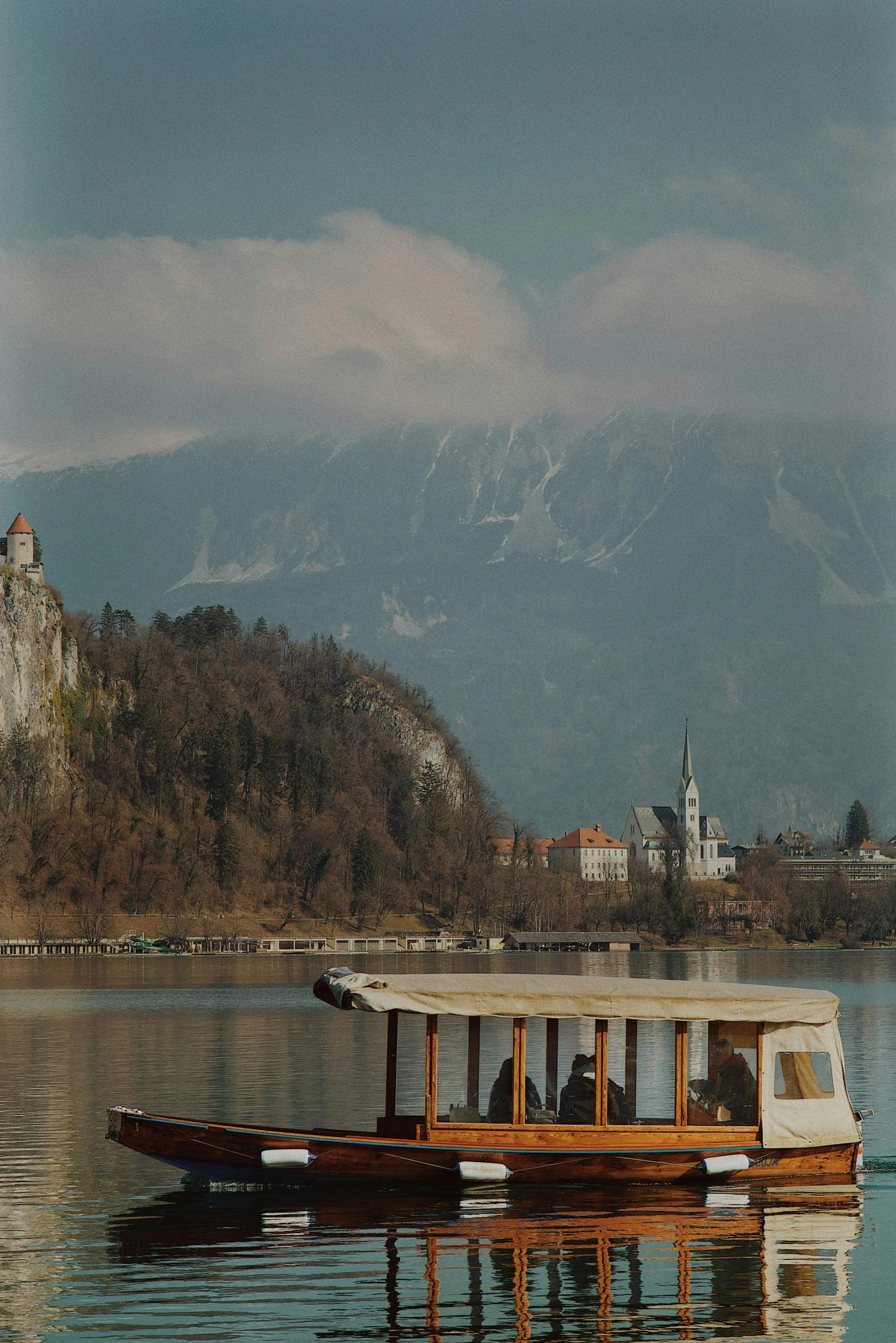 a boat that is sitting in the water, a picture, inspired by Henryk Siemiradzki, pexels contest winner, romanticism, mountains and a huge old city, medium format. soft light, tall spires, view from the lake