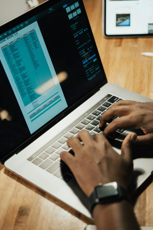 a person typing on a laptop computer on a wooden table, afro tech, thumbnail, multiple stories, - 9